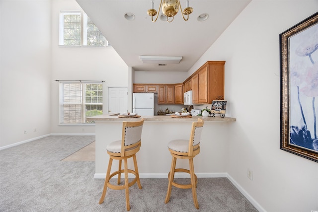 155 Chenoa Dr Unit E, Murrells Inlet, SC 29576 - kitchen featuring white appliances, light colored carpet, a peninsula, and light countertops