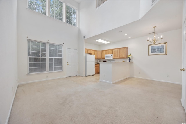 155 Chenoa Dr Unit D, Murrells Inlet, SC 29576 - unfurnished living room featuring a chandelier, light colored carpet, and a towering ceiling