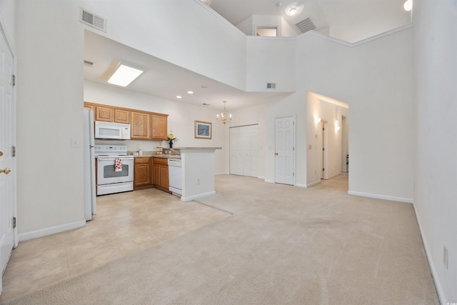 155 Chenoa Dr Unit D, Murrells Inlet, SC 29576 - kitchen with white appliances, a chandelier, a peninsula, light colored carpet, and a towering ceiling
