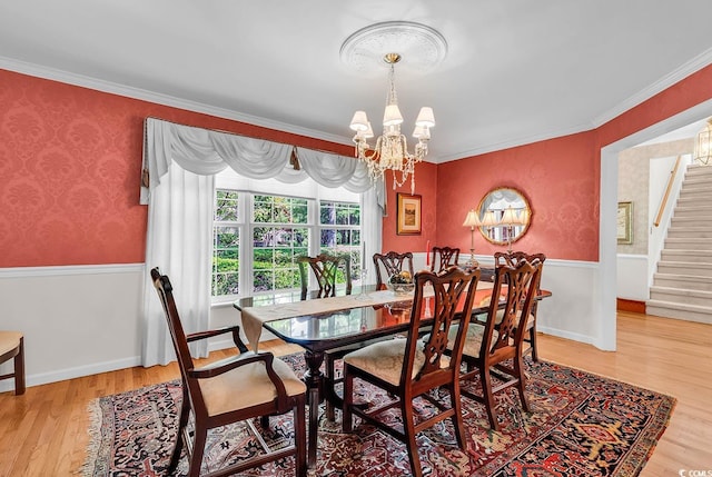 241 Black Duck Rd, Pawleys Island, SC 29585 - dining room featuring a chandelier, stairs, light wood finished floors, crown molding, and wallpapered walls