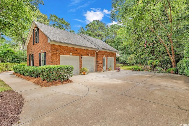 241 Black Duck Rd, Pawleys Island, SC 29585 - view of side of property with brick siding, driveway, a shingled roof, and an attached garage