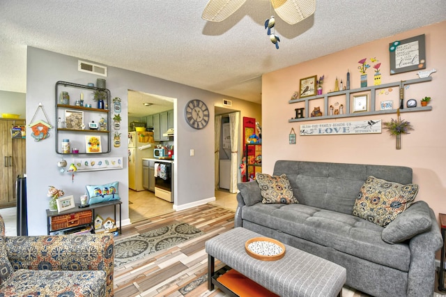 1025 Plantation Dr Unit 2413/2414, Little River, SC 29566 - living area with light wood-type flooring, a textured ceiling, and ceiling fan