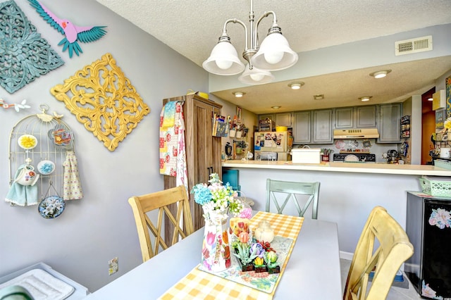 1025 Plantation Dr Unit 2413/2414, Little River, SC 29566 - dining area featuring a chandelier and a textured ceiling