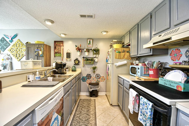 1025 Plantation Dr Unit 2413/2414, Little River, SC 29566 - kitchen with white appliances, under cabinet range hood, light countertops, light tile patterned floors, and a textured ceiling