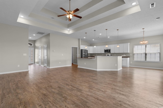 347 Leste Rd, Myrtle Beach, SC 29588 - unfurnished living room with a tray ceiling, dark wood-type flooring, a ceiling fan, recessed lighting, and a chandelier
