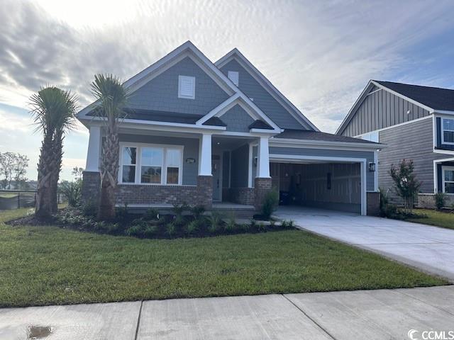 2256 Vera Way, Longs, SC 29568 - craftsman house with a porch, concrete driveway, a garage, a front yard, and brick siding