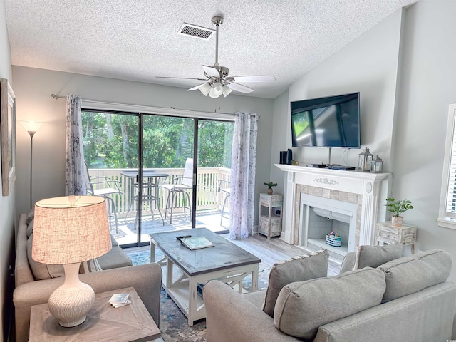 145 Hartland Dr Unit 4-E, Myrtle Beach, SC 29572 - living area with ceiling fan, a textured ceiling, a tile fireplace, and lofted ceiling