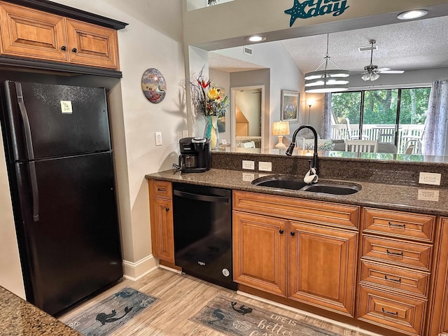 145 Hartland Dr Unit 4-E, Myrtle Beach, SC 29572 - kitchen with black appliances, light wood-style floors, brown cabinets, dark stone counters, and a ceiling fan