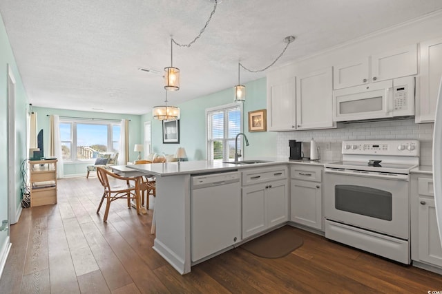 4105 S Ocean Blvd Unit 102, North Myrtle Beach, SC 29582 - kitchen with white appliances, a peninsula, open floor plan, a textured ceiling, and dark wood-style flooring