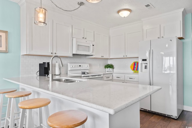 4105 S Ocean Blvd Unit 102, North Myrtle Beach, SC 29582 - kitchen featuring white appliances, a peninsula, backsplash, white cabinetry, and dark wood finished floors