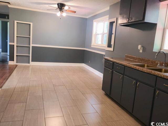 3110 Pinewood Dr, Loris, SC 29569 - kitchen featuring ceiling fan, crown molding, dark countertops, and dark cabinets