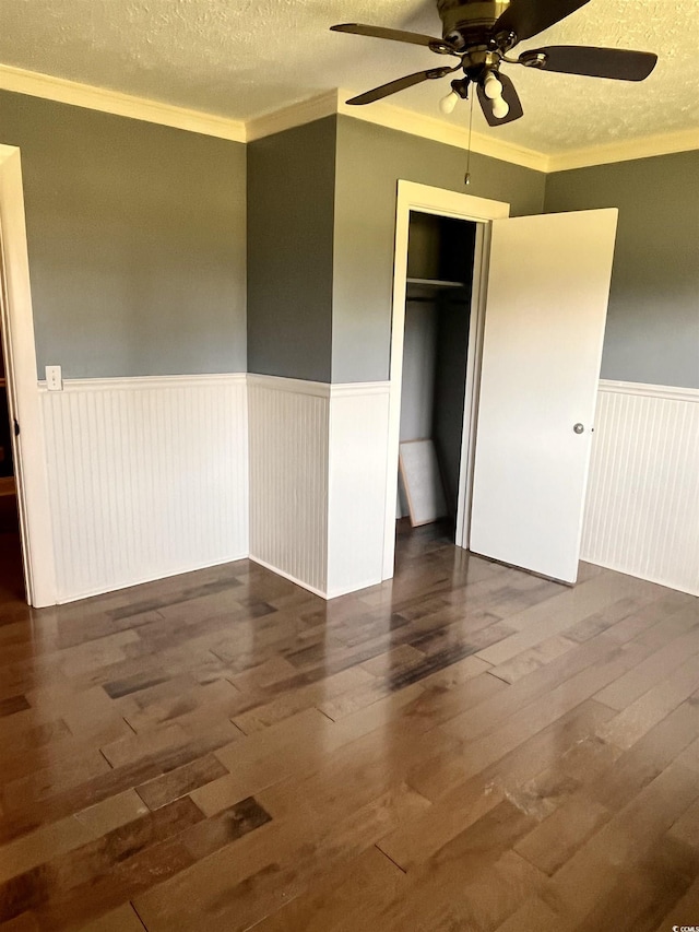 3110 Pinewood Dr, Loris, SC 29569 - unfurnished bedroom with a wainscoted wall, wood-type flooring, a textured ceiling, crown molding, and a closet