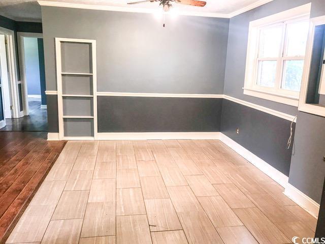 3110 Pinewood Dr, Loris, SC 29569 - unfurnished room featuring a ceiling fan, wood finished floors, and crown molding