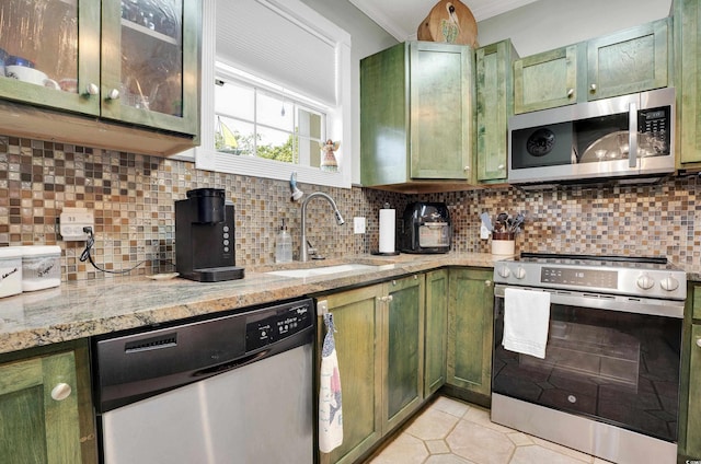 4221 Hibiscus Dr Unit 8-203, Little River, SC 29566 - kitchen with green cabinetry, stainless steel appliances, ornamental molding, decorative backsplash, and light stone counters