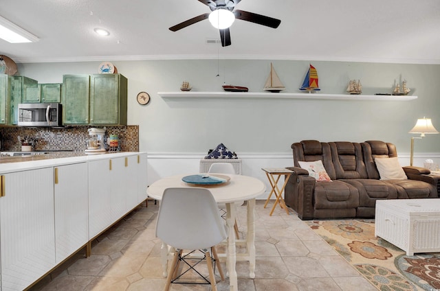 4221 Hibiscus Dr Unit 8-203, Little River, SC 29566 - kitchen with stainless steel microwave, ornamental molding, green cabinets, a ceiling fan, and light countertops