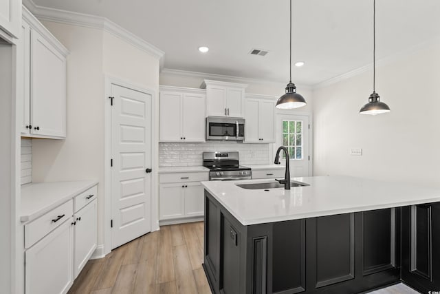 1718 26th Ave N, North Myrtle Beach, SC 29582 - kitchen featuring appliances with stainless steel finishes, white cabinets, light wood finished floors, ornamental molding, and recessed lighting
