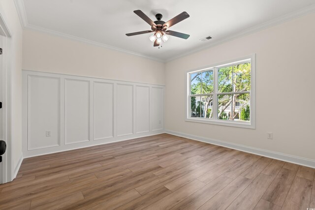 1718 26th Ave N, North Myrtle Beach, SC 29582 - unfurnished room with a decorative wall, light wood finished floors, a ceiling fan, ornamental molding, and wainscoting