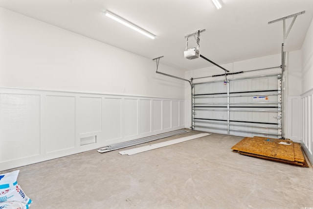1718 26th Ave N, North Myrtle Beach, SC 29582 - garage with a garage door opener, a decorative wall, and wainscoting