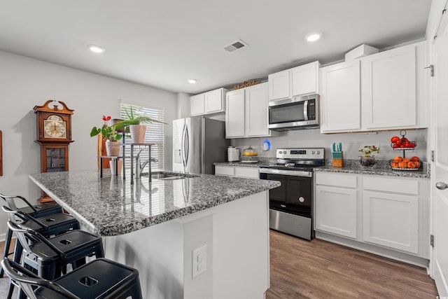 190 Belmonte Dr, Myrtle Beach, SC 29588 - kitchen featuring appliances with stainless steel finishes, a breakfast bar area, white cabinetry, stone counters, and recessed lighting
