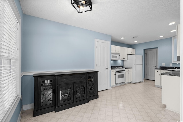 4162 Dupree Dr, Little River, SC 29566 - kitchen featuring white appliances, dark countertops, white cabinets, a textured ceiling, and light floors