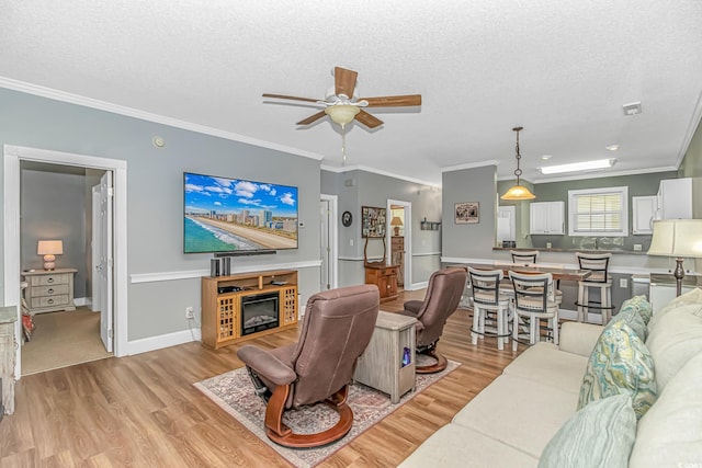 4173 Hibiscus Dr Unit 103, Little River, SC 29566 - living area with light wood-type flooring, a textured ceiling, ceiling fan, crown molding, and a glass covered fireplace