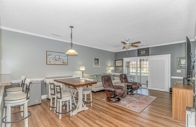 4173 Hibiscus Dr Unit 103, Little River, SC 29566 - dining room with a textured ceiling, ceiling fan, crown molding, and light wood-type flooring