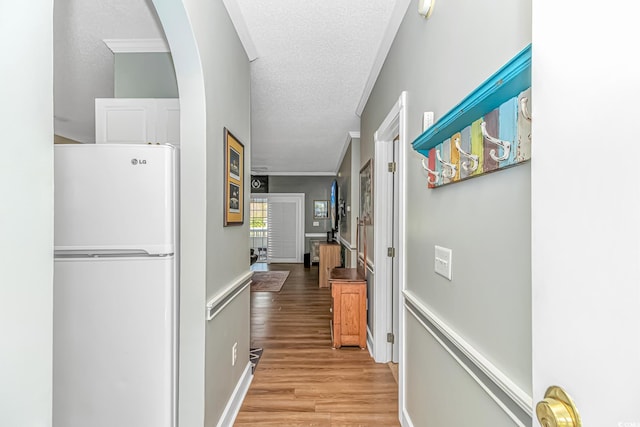 4173 Hibiscus Dr Unit 103, Little River, SC 29566 - hallway featuring a textured ceiling, light wood-type flooring, crown molding, and arched walkways