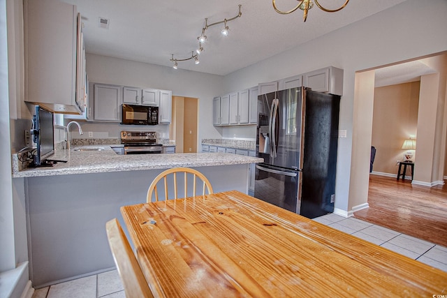1409 Ashwood Cir, Surfside Beach, SC 29575 - kitchen with appliances with stainless steel finishes, gray cabinets, light tile patterned floors, and a peninsula