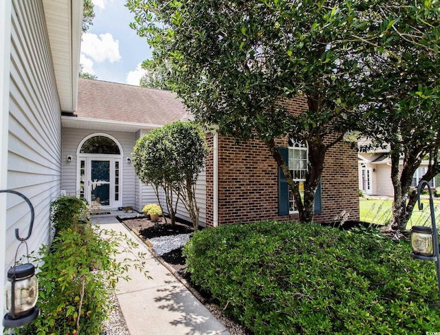 1409 Ashwood Cir, Surfside Beach, SC 29575 - doorway to property with brick siding and roof with shingles