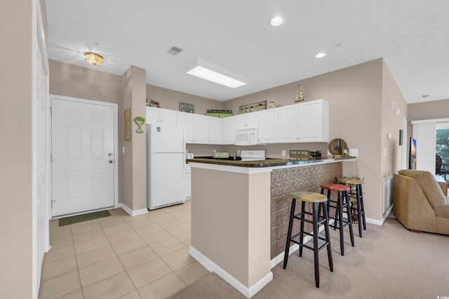 601 N Hillside Dr Unit 3926, North Myrtle Beach, SC 29582 - kitchen with white appliances, a peninsula, a kitchen breakfast bar, white cabinets, and dark countertops