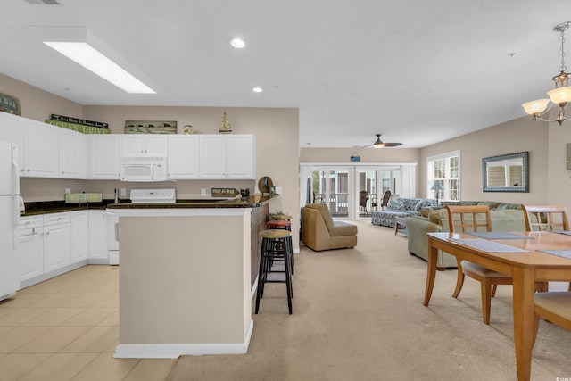 601 N Hillside Dr Unit 3926, North Myrtle Beach, SC 29582 - kitchen with white appliances, dark countertops, a breakfast bar, white cabinets, and recessed lighting