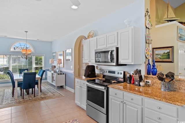 5712 Whistling Duck Dr, North Myrtle Beach, SC 29582 - kitchen with stainless steel appliances, a chandelier, white cabinets, light stone countertops, and decorative light fixtures