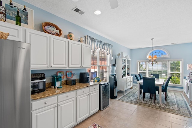 5712 Whistling Duck Dr, North Myrtle Beach, SC 29582 - kitchen with freestanding refrigerator, wine cooler, white cabinetry, decorative light fixtures, and a chandelier