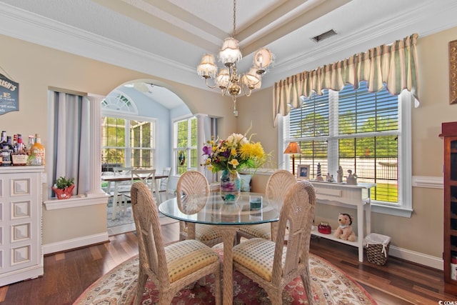 5712 Whistling Duck Dr, North Myrtle Beach, SC 29582 - dining space with arched walkways, hardwood / wood-style flooring, a chandelier, ornamental molding, and a raised ceiling