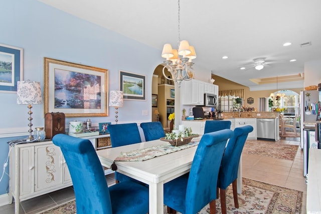 5712 Whistling Duck Dr, North Myrtle Beach, SC 29582 - dining area featuring a chandelier, arched walkways, a ceiling fan, recessed lighting, and light tile patterned flooring