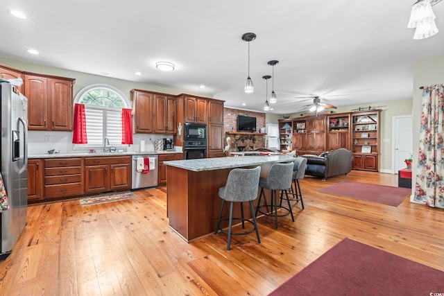 4691 Mill Pond Ct, Murrells Inlet, SC 29576 - kitchen with black appliances, light wood-style flooring, ceiling fan, open floor plan, and pendant lighting