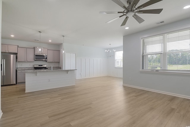 964 Irving Dr, Little River, SC 29566 - unfurnished living room with a chandelier, a ceiling fan, light wood-style flooring, recessed lighting, and a wainscoted wall
