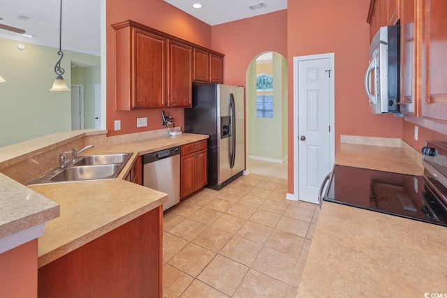 56 Willowbend Dr, Murrells Inlet, SC 29576 - kitchen with stainless steel appliances, arched walkways, light countertops, light tile patterned floors, and decorative light fixtures
