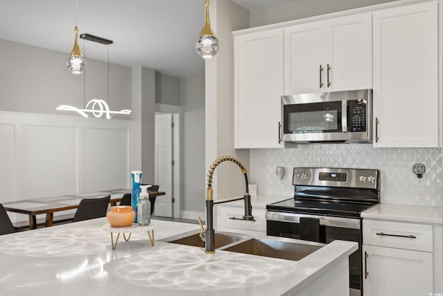 2143 Stonecrest Dr NW, Calabash, NC 28467 - kitchen with appliances with stainless steel finishes, tasteful backsplash, white cabinetry, a decorative wall, and hanging light fixtures
