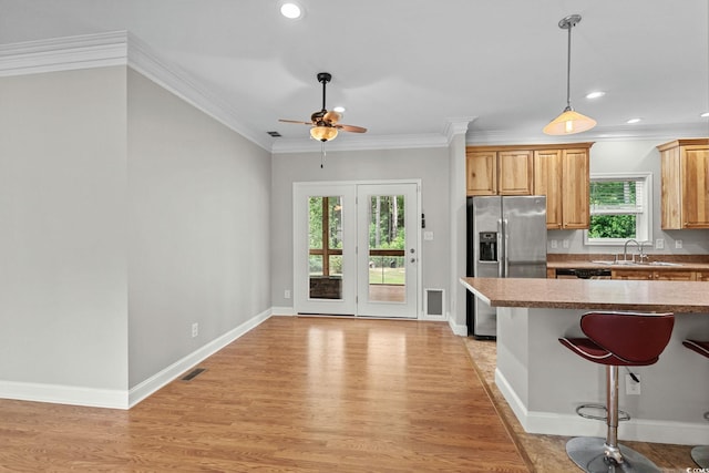 2135 Starduster Ln, Little River, SC 29566 - kitchen with stainless steel refrigerator with ice dispenser, plenty of natural light, ceiling fan, a breakfast bar, and ornamental molding