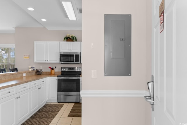 4872 Dahlia Ct Unit 305, Myrtle Beach, SC 29577 - kitchen featuring appliances with stainless steel finishes, electric panel, white cabinets, light tile patterned floors, and crown molding