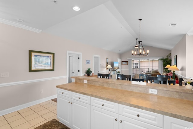 4872 Dahlia Ct Unit 305, Myrtle Beach, SC 29577 - kitchen featuring lofted ceiling, white cabinetry, light countertops, light tile patterned flooring, and decorative light fixtures