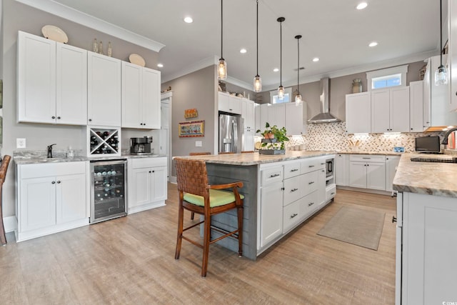 1106 Bluffton Ct, Myrtle Beach, SC 29579 - kitchen featuring wall chimney range hood, wine cooler, stainless steel fridge with ice dispenser, a center island, and crown molding