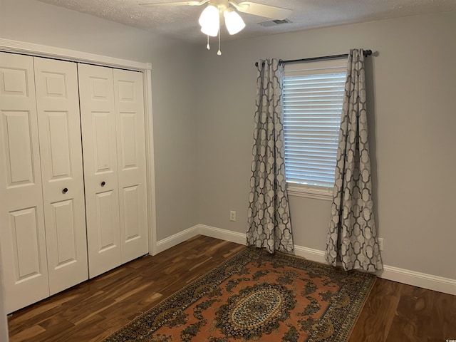 312 Trace Run, Myrtle Beach, SC 29588 - unfurnished bedroom with dark wood-type flooring, multiple windows, a closet, a textured ceiling, and ceiling fan