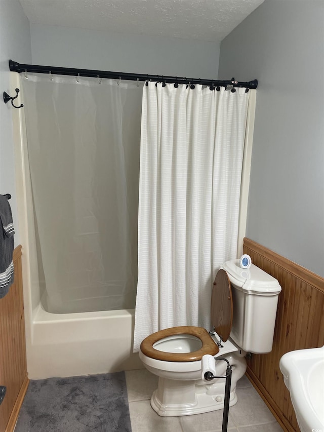 312 Trace Run, Myrtle Beach, SC 29588 - bathroom featuring shower / bath combo with shower curtain, wooden walls, tile patterned flooring, wainscoting, and a textured ceiling