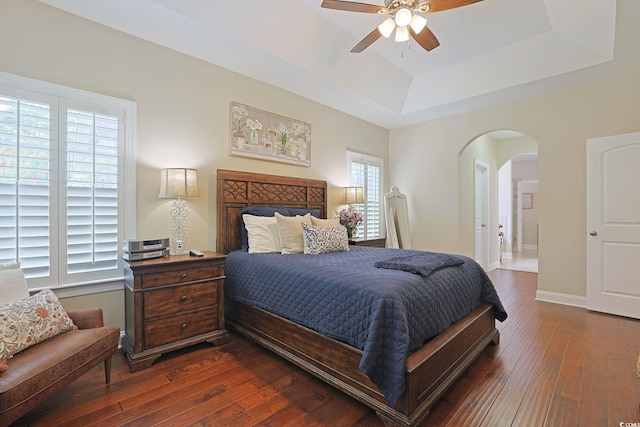 428 Arlington Cir, Murrells Inlet, SC 29576 - bedroom with a tray ceiling, arched walkways, dark wood-style floors, and a ceiling fan