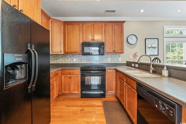 670 2nd Ave N, North Myrtle Beach, SC 29582 - kitchen featuring black appliances, light wood-type flooring, crown molding, backsplash, and brown cabinets