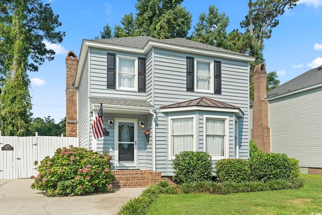 1575 Victoria Ln, Myrtle Beach, SC 29577 - traditional home with a gate, a chimney, a standing seam roof, and a shingled roof