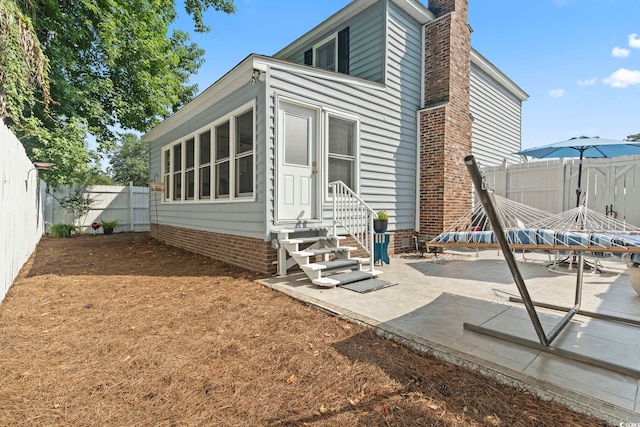 1575 Victoria Ln, Myrtle Beach, SC 29577 - rear view of house with entry steps, a chimney, a patio, and a fenced backyard