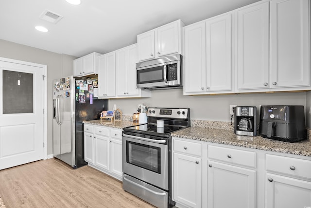 317 Truce St, Myrtle Beach, SC 29588 - kitchen with stainless steel appliances, light wood-style floors, white cabinets, light stone counters, and recessed lighting